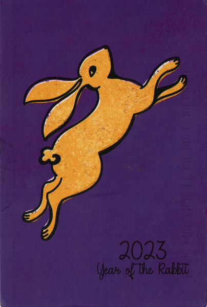 Auf einer lila Karte sieht man einen gold-gelben Hasen, der nach rechts oben spingt. Der Hase ist mit einer schwarzen Linie umrandet. DArunter steht 2023 - year of the rabbit.